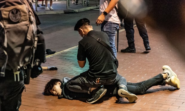 An anti-government protester is detained by police in Mongkok.