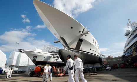 Workers walk past super yachts at the MB92 yard in  Barcelona.