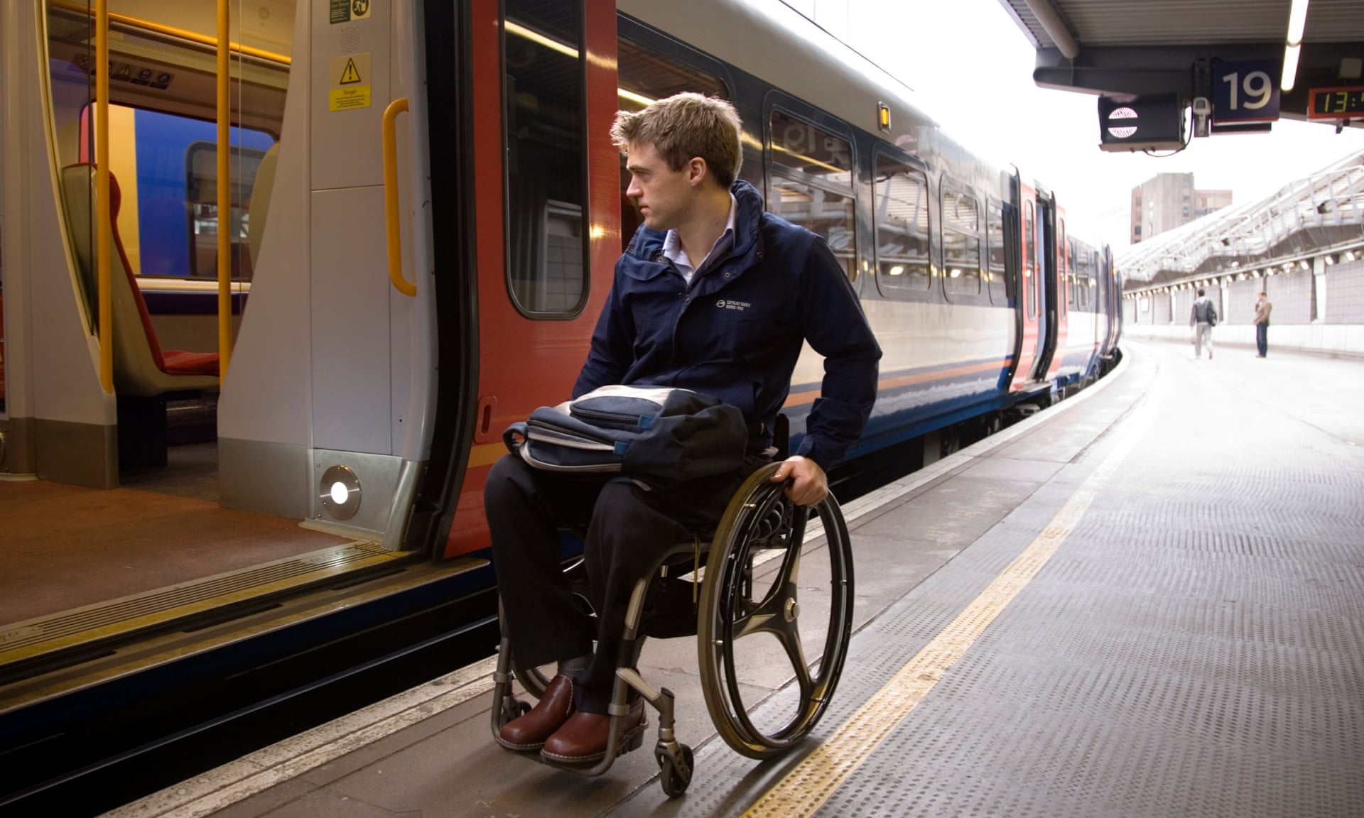 Un usuario de silla de ruedas se prepara para intentar abordar un tren en una estación de Londres. Fotografía: Alamy