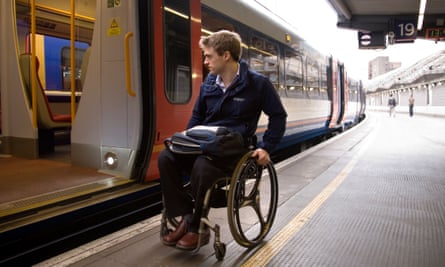 A wheelchair user prepares to attempt to board a train at a London station.