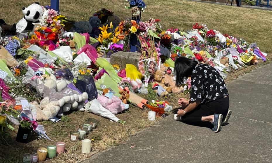 A mourner lights a candle at the scene of the jumping castle accident in Devonport, Tasmania, Australia.
