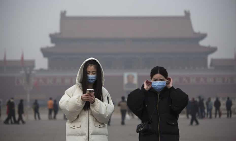 Women wear masks to protect against pollution as they visit Tiananmen Square, Beijing