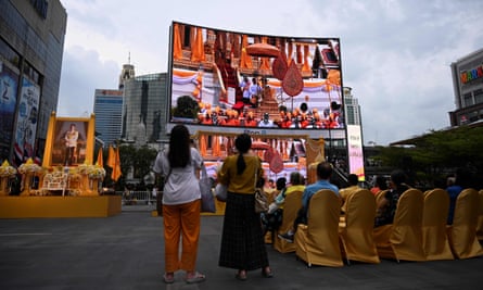 People watch the live broadcast of the coronation ceremony in Bangkok.