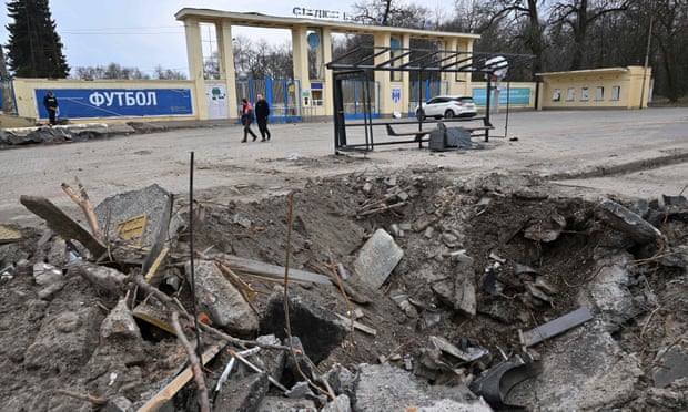 A crater at the entrance of a destroyed stadium in Ukraine.