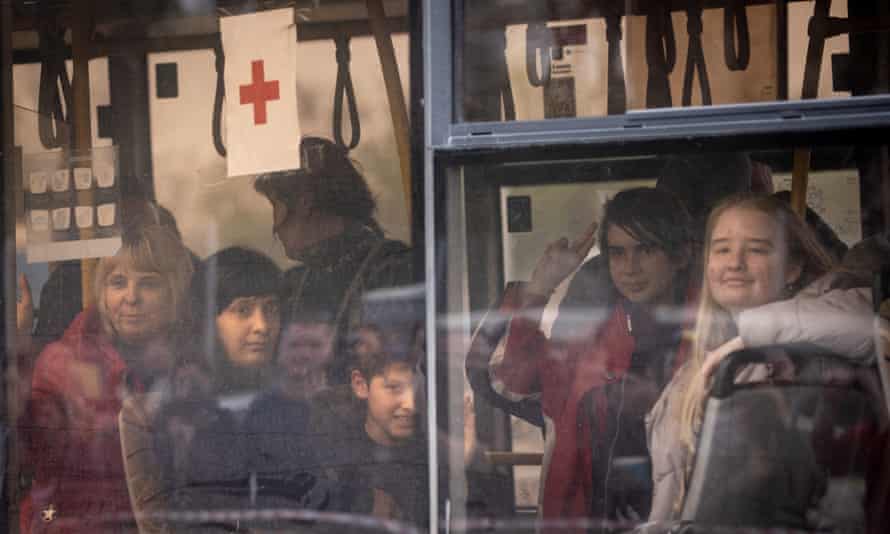 Evacuees including some from the Azovstal plant wave as they arrive on a bus at an evacuation point in Zaporizhzhia, Ukraine.