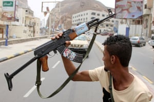 Un membre du séparatiste du sud du Yémen tient son arme avec une photo du général Bridgadier Muneer al-Yafee, tué lors d’une attaque par missile Houthi à Aden.