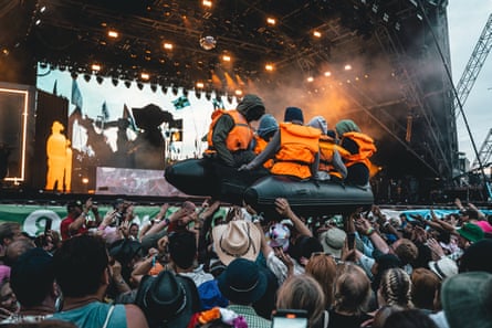 An inflatable migrant boat is carried across the crowd during Little Simz set on the Pyramid Stage at the Glastonbury festival on 29 June.