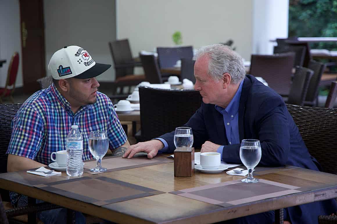 Two men sit at a table together