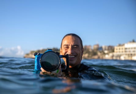 Photographer Eugene Tan in the water with his camera at Bondi