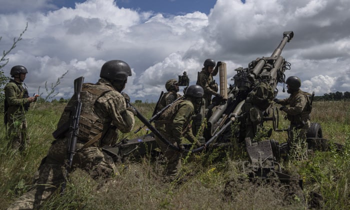 Team of soldiers working around a gun in a field