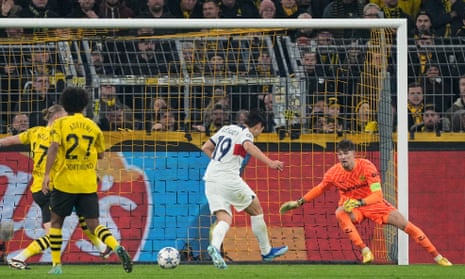 PSG's Lee Kang-in (centre) shoots past Dortmund's goalkeeper Gregor Kobel (right) but also wide of the goal.