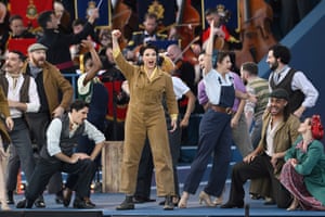 Emma Barton in boiler suit holds up her hand in a in a live performance