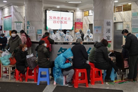 People wait in line on stools at Wuhan Red Cross Hospital