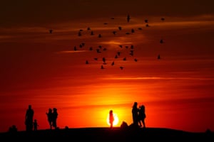 London, UK.  Groups of people watch the sun go down from a hill in Ealing, west London, as a summer of hosepipe bans and fire warnings continues