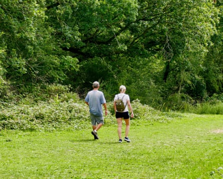 A man and woman off for a walk in the countryside, wearing T-shirts and shorts