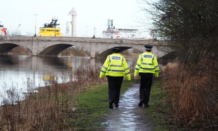 Police officers walk next to River Dee in Aberdeen during the search for missing sisters, Eliza and Henrietta Huszti.