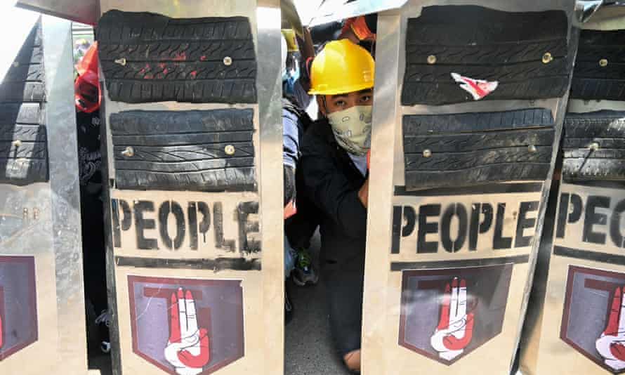 A protester looks on from behind shields during a demonstration against the military coup in Yangon on Sunday.