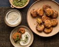 Thomasina Miers' pumpkin and carrot fritters green chilli coriander relish.... Overhead view of pumpkin and carrot fritters on a plate beside yoghurt and green chilli coriander relish