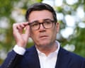Andy Burnham touches arm of his glasses