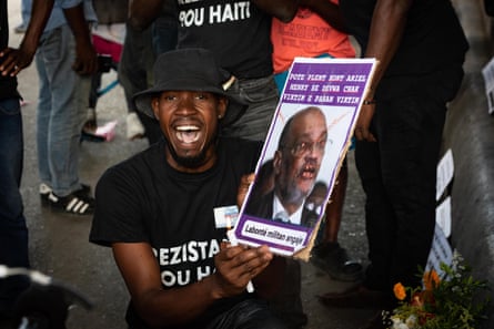 A man holds a poster protesting Haiti’s prime minister, Ariel Henry, in Puerto Principe, Haiti, on 3 September 2023.