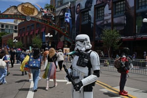 A fan dressed as a Storm Trooper from Star Wars stands on the street