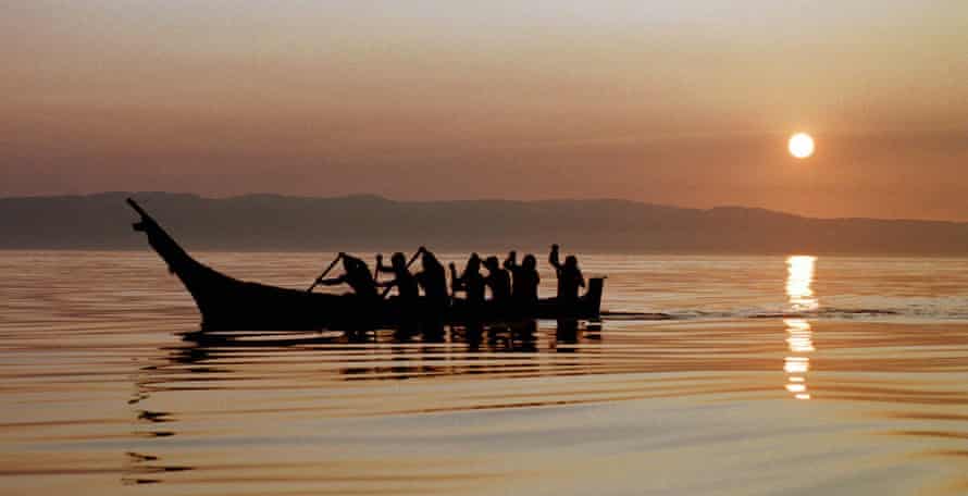 Members of the Makah Tribe paddle away from the rising sun as they head from Neah Bay, Washington, toward open Pacific Ocean waters during a practice for a planned whale hunt in 1998.