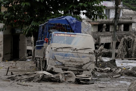 A vehicle is covered with mud following a flash flood at Trishuli.