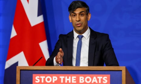 Rishi Sunak stands behind a lectern that says 'stop the boats'.