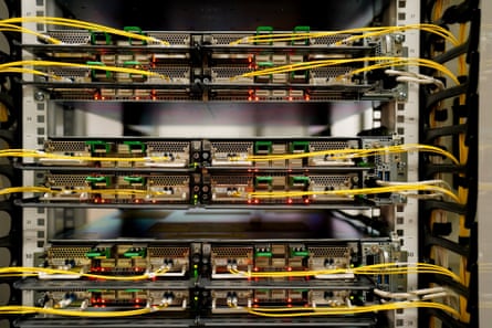 View of some computer units in a large rack connected to one another with thin cables
