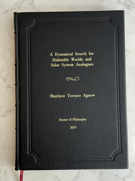 The front cover of a black bound leather book, with golden embossed text that reads: A Dynamical Search for Habitable Worlds and Solar System Analogues, Matthew Terence Agnew