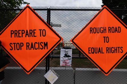 Placards placed by protesters hang from a fence erected in front of Lafayette Park near the White House in June.