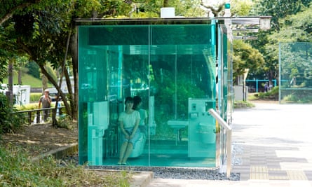 An employee of the Nippon Foundation demonstrates the transparent public toilet
