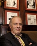 Martin Rowson sitting in front of his pen portraits at the Gay Hussar in 2007.
