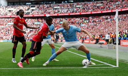 Erling Haaland repousse un défenseur de Manchester United