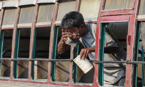 A man washes her face through the window a bus during a heatwave in Kolkata, India.