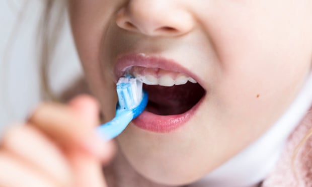 Young girl brushing her milk teeth, close-up