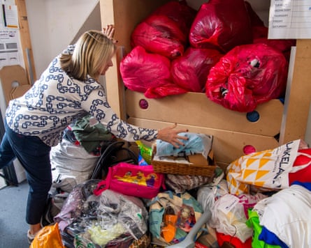 A charity shop worker sorts through donations.