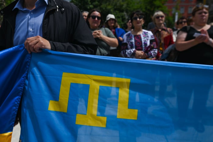 Members of the local Ukrainian diaspora holding the flag of the Crimean Tatar people.