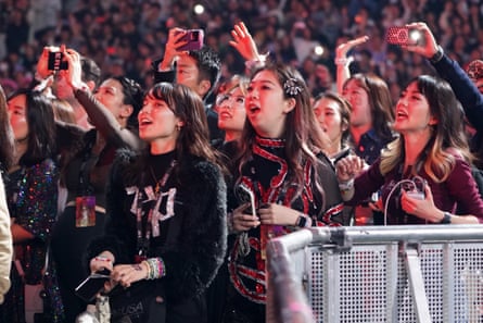 Fans watch on as Taylor Swift performs onstage during in Tokyo.
