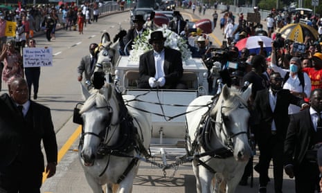 A horse-drawn carriage carries Floyd’s casket to the Houston Memorial Gardens cemetery in Pearland.