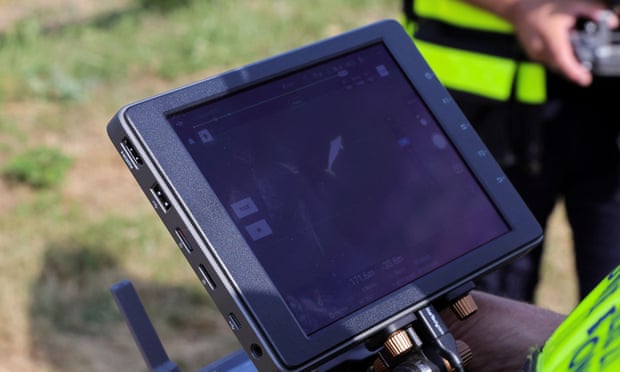 Un pompier surveille les mouvements du béluga depuis un drone volant au-dessus de lui.