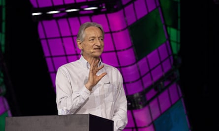 Man gestures while giving talk in front of purple-grid graphics