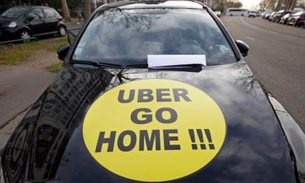 A striking French taxi driver displays the message ‘Uber go home’ on his car in January 2016