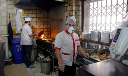 A chef works in a mask at a restaurant in Tehran