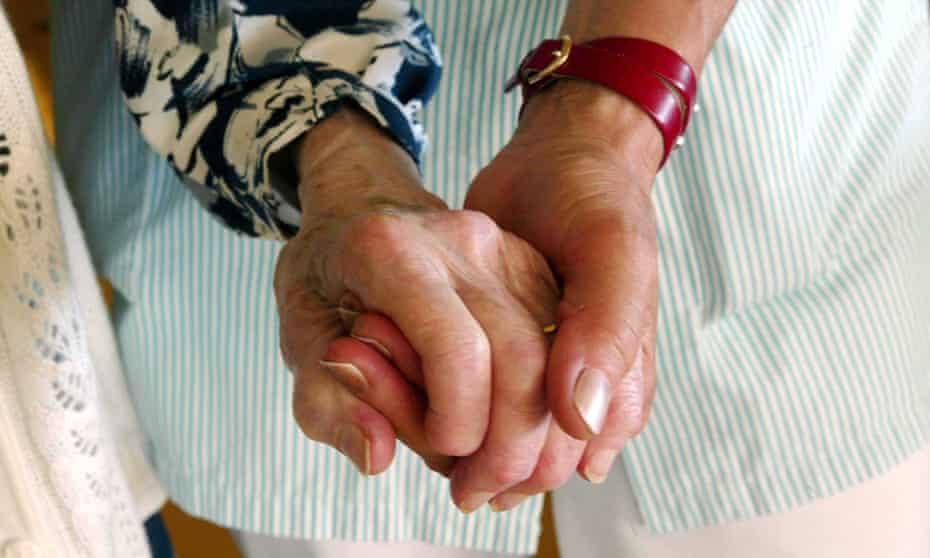 A care worker helps an elderly client