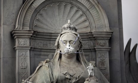 Greenpeace protesters put a face mask on the statue of Queen Victoria opposite Buckingham Palace to highlight air pollution