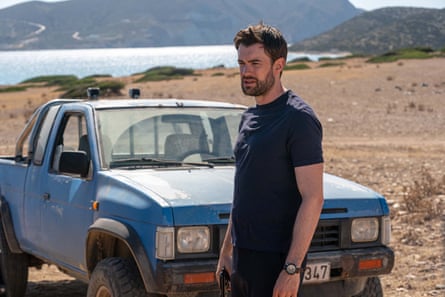 Jack Whitehall as Adam in Malice, standing in front of a pickup truck on a beach.