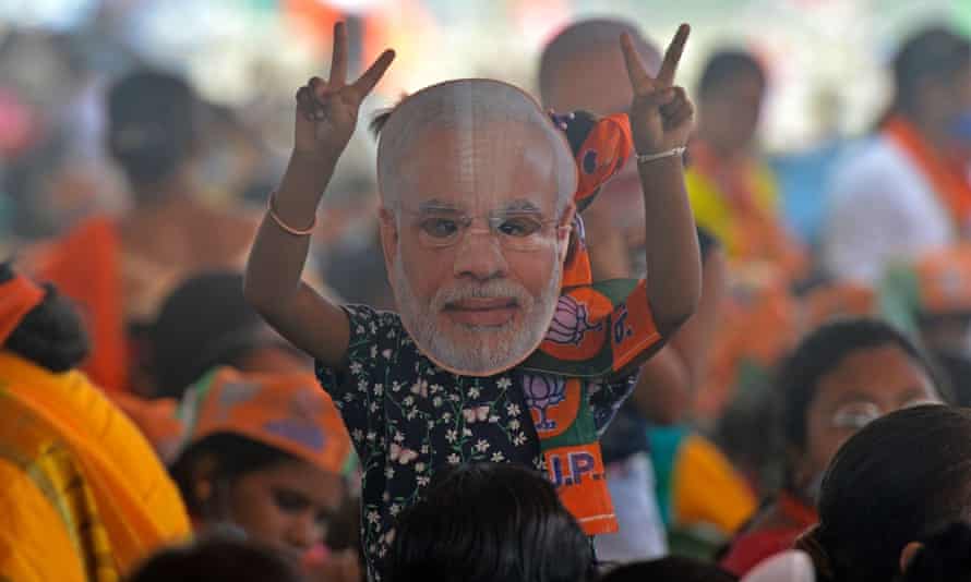 حضر أحد مناصري حزب بهاراتيا جاناتا (BJP) الذي يرتدي قطعًا وجهًا لرئيس الوزراء الهندي ناريندرا مودي ، وهو أحد مؤيدي التصويت في السياسة الهندية ، تجمعًا عامًا في ضواحي جواهاتي خلال المرحلة الرابعة من انتخابات مجلس الولاية في ولاية البنغال الغربية.  من سيليجوري في 10 أبريل 2021.  (تصوير ديبتند توتا / وكالة الصحافة الفرنسية) (تصوير ديبتند توتا / وكالة فرانس برس عبر غيتي إيماجز
