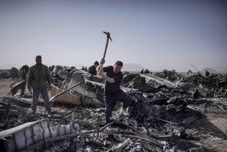 Municipality workers and Iranian army personnel clear the site where two US C-130 military transport planes and at least two helicopters were destroyed
