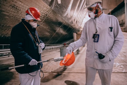 Workers check the radiation level of a helmet that accidentally fell on the floor inside Chornobyl’s safe confinement shelter.